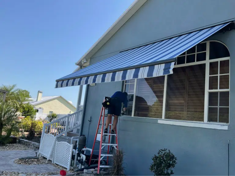 Retractable awning being maintained on a home exterior