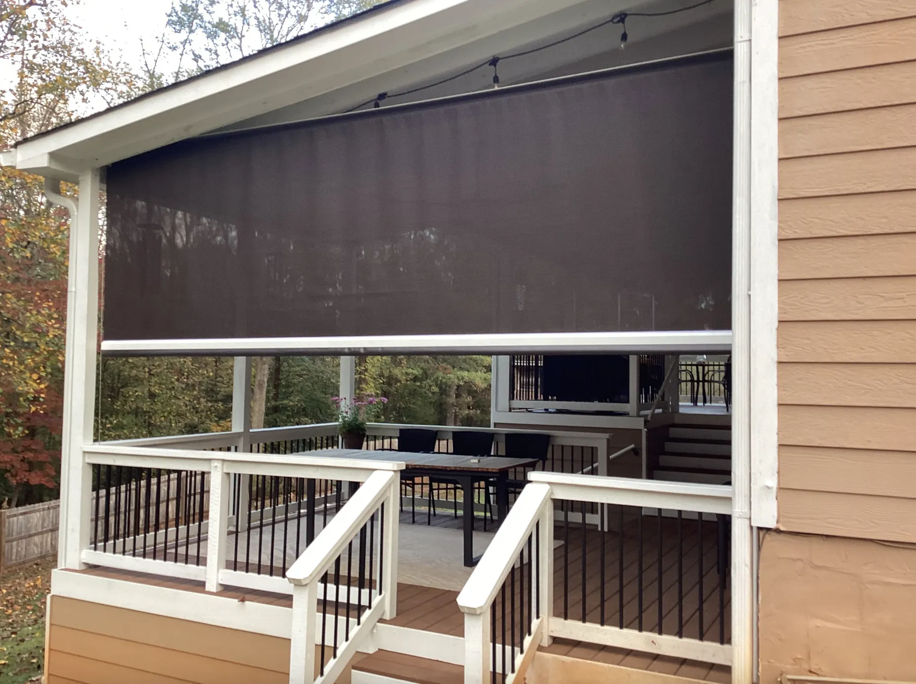 motorized retractable screen lowered over covered patio