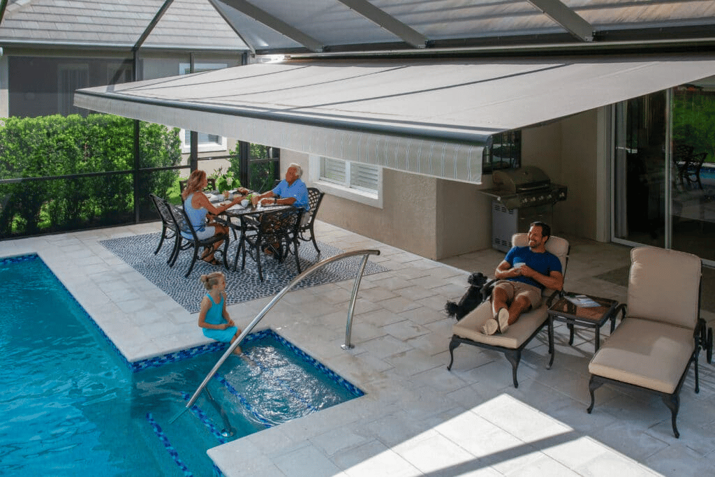 Retractable awning and outdoor screen shading a poolside patio